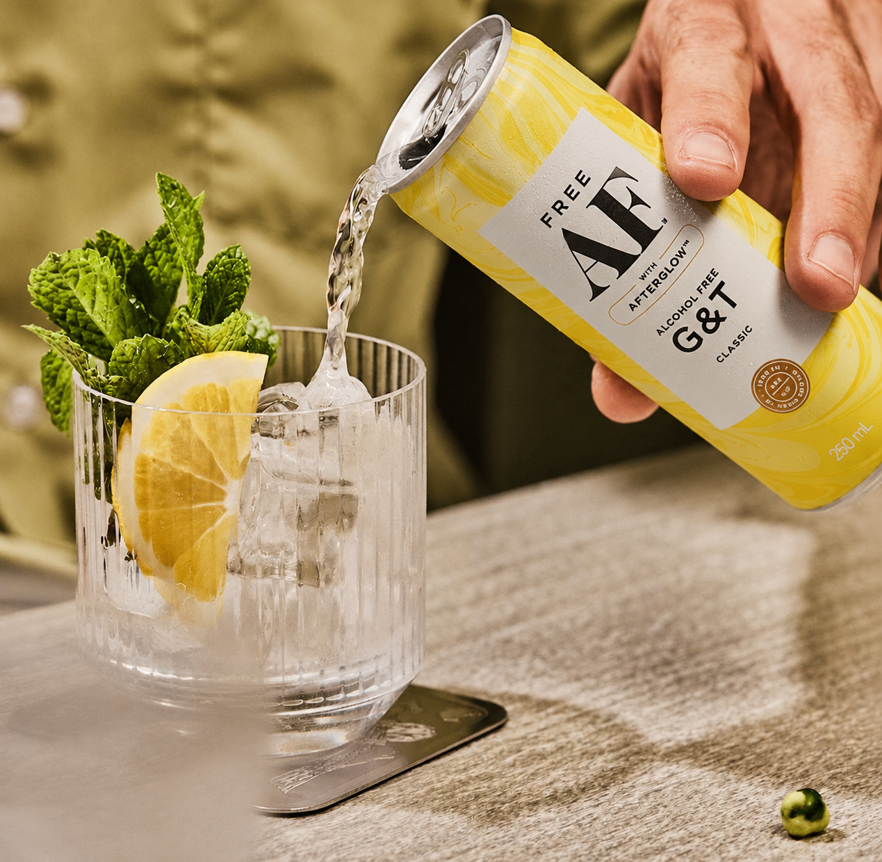 Alcohol-free G&T being poured into a glass with lemon and ice.