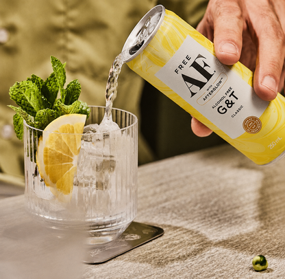 Alcohol-free G&T being poured into a glass with lemon and ice.