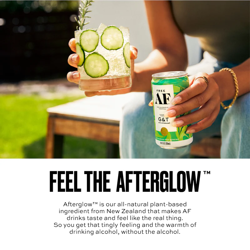 Person holding a can of AF G&T with a cocktail garnished with cucumbers outdoors.